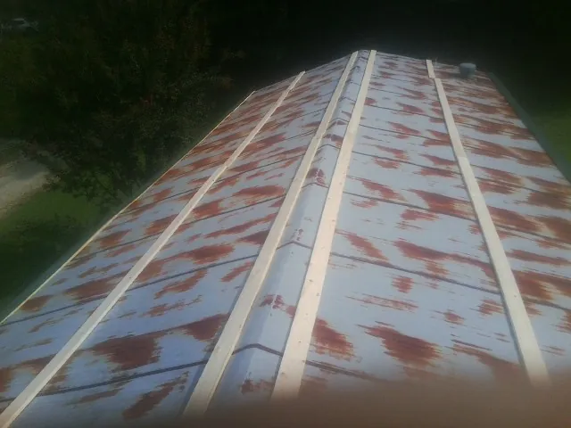 Rusted metal roof panels with new wood purlins before replacement — Storm Damage Roof Repair in Winner by Roofing Brothers